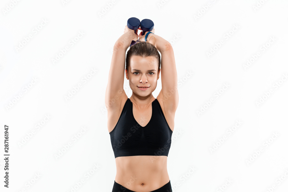 Fototapeta premium Young sporty blond woman in a black sportswear exercising with hand weights isolated over white background.