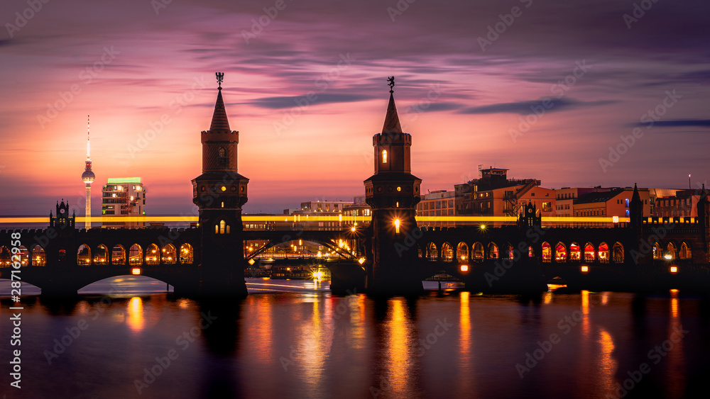 Naklejka premium Beautiful sunset view at the Oberbaum Bridge in Berlin with the famous Television Tower in the back
