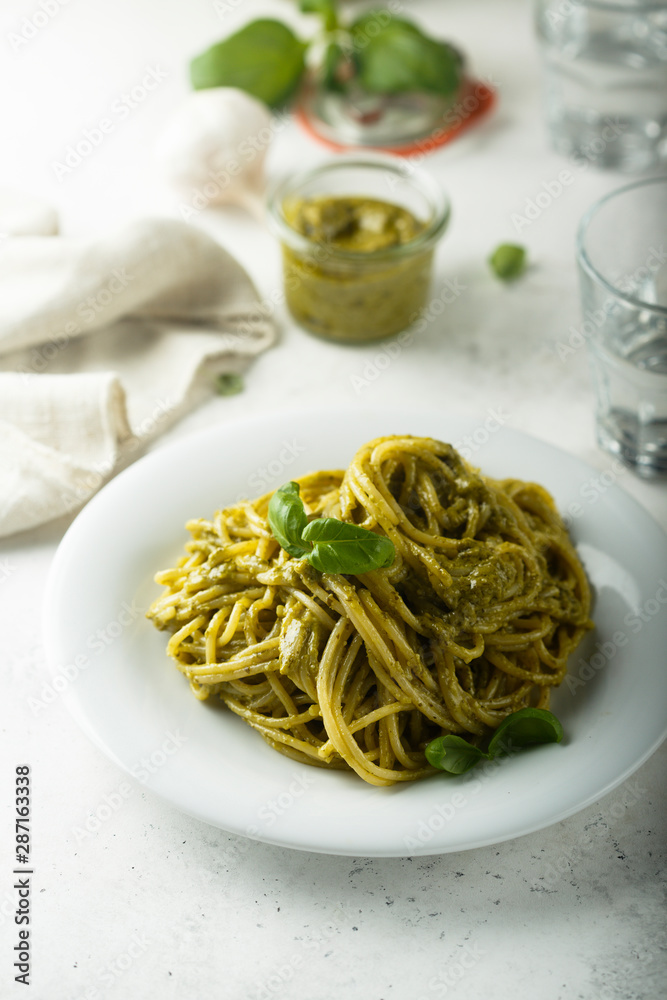 Pasta with pesto sauce and fresh basil leaves