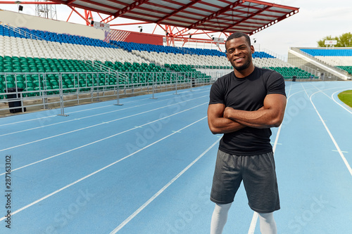 sport achievement. Confident afro american cheerful athlete sportsman holds hands crossed looking at the camera. copy space. health and body care
