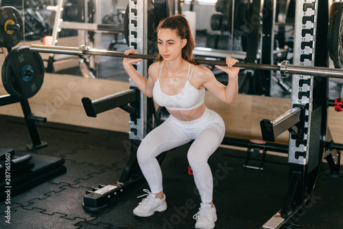 A young athletic girl does exercises using sports equipment in gym