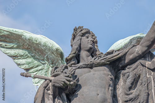 Old statue of a black angel as a warrior with green wings at the roof top of the central historical building of Albertinum museum in downtown of Dresden, Germany photo