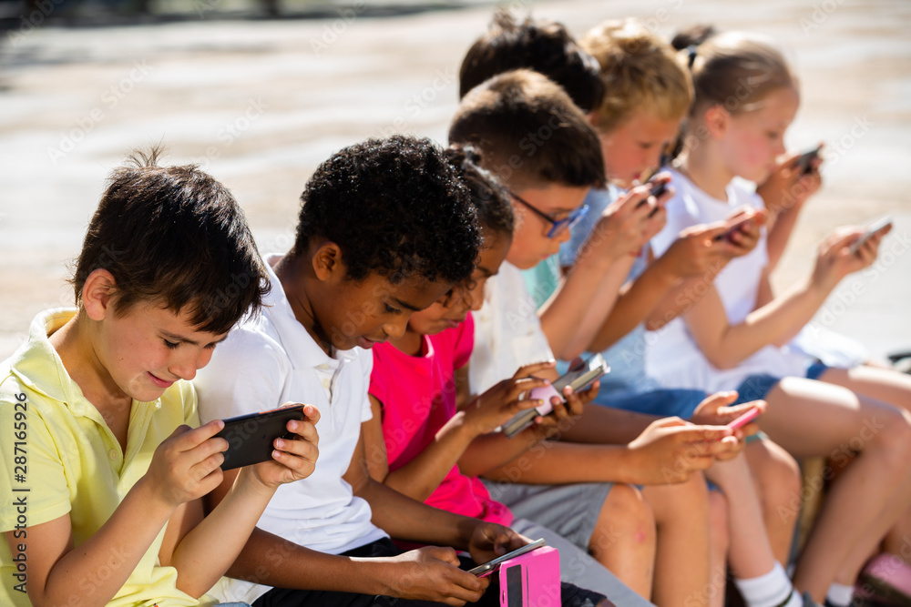 Obraz premium Children are playing on smartphone in the playground