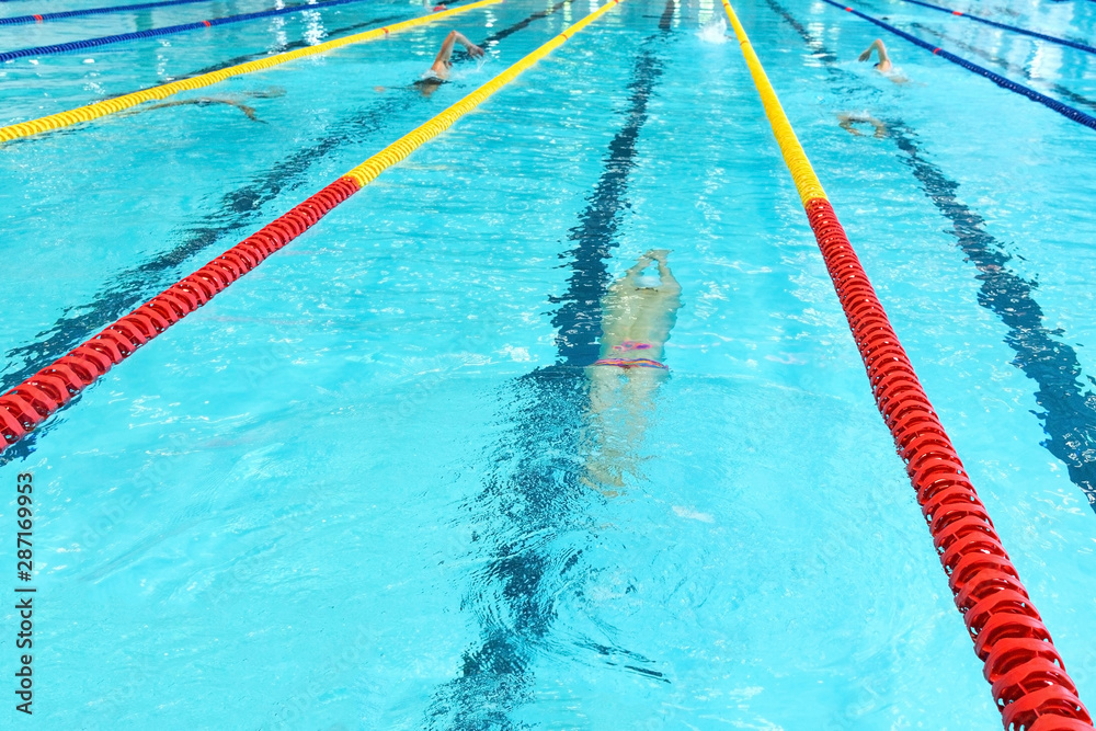 A teenage athlete is swimming crowl. Without face, selective focus.