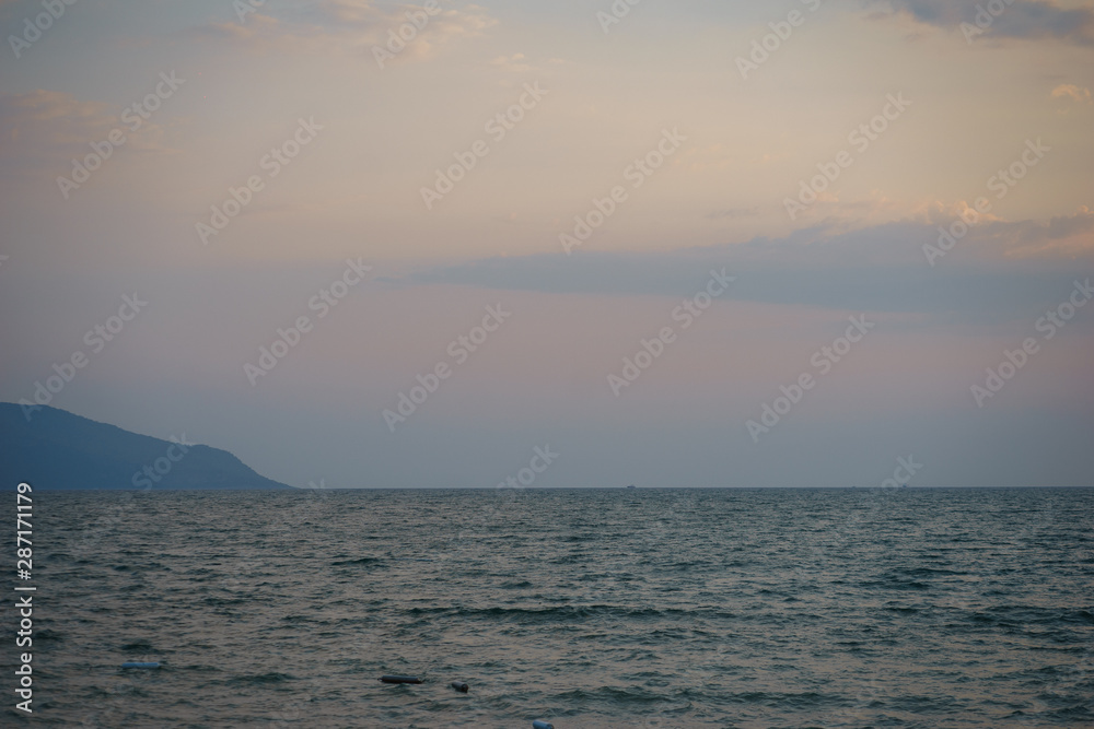 Sunset on the sandy beach with sea view. Seascape.