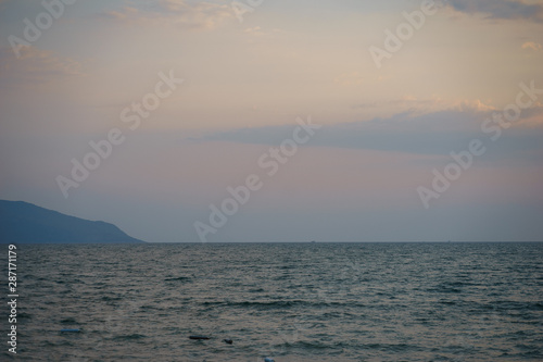 Sunset on the sandy beach with sea view. Seascape.