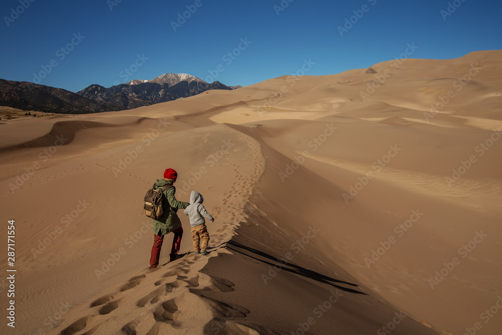 A man with his son are hiking in desert A man with his son are hiking in desert