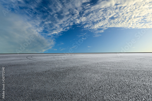 Empty race track road and blue sky with white clouds © ABCDstock