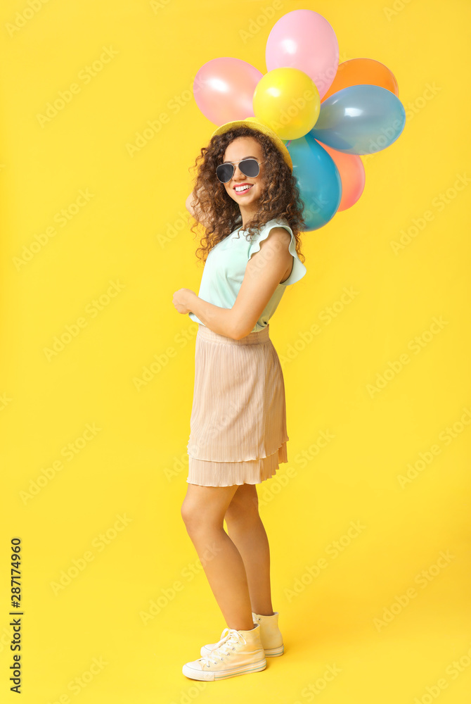 Happy African-American woman with air balloons on color background Happy African-American woman with air balloons on color background