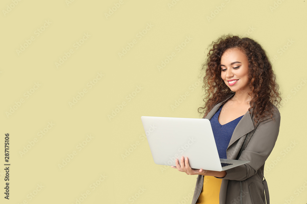 Stylish African-American woman with laptop on color background Stylish African-American woman with laptop on color background