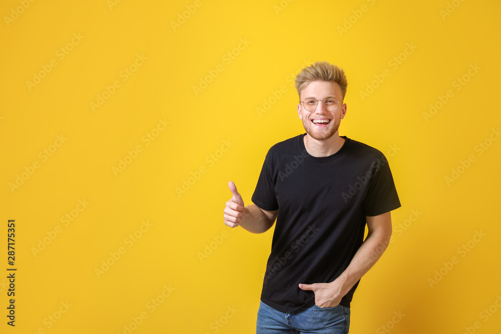Man in stylish t-shirt showing thumb-up on color background Man in stylish t-shirt showing thumb-up on color background
