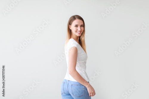 Woman in stylish t-shirt on light background © Pixel-Shot