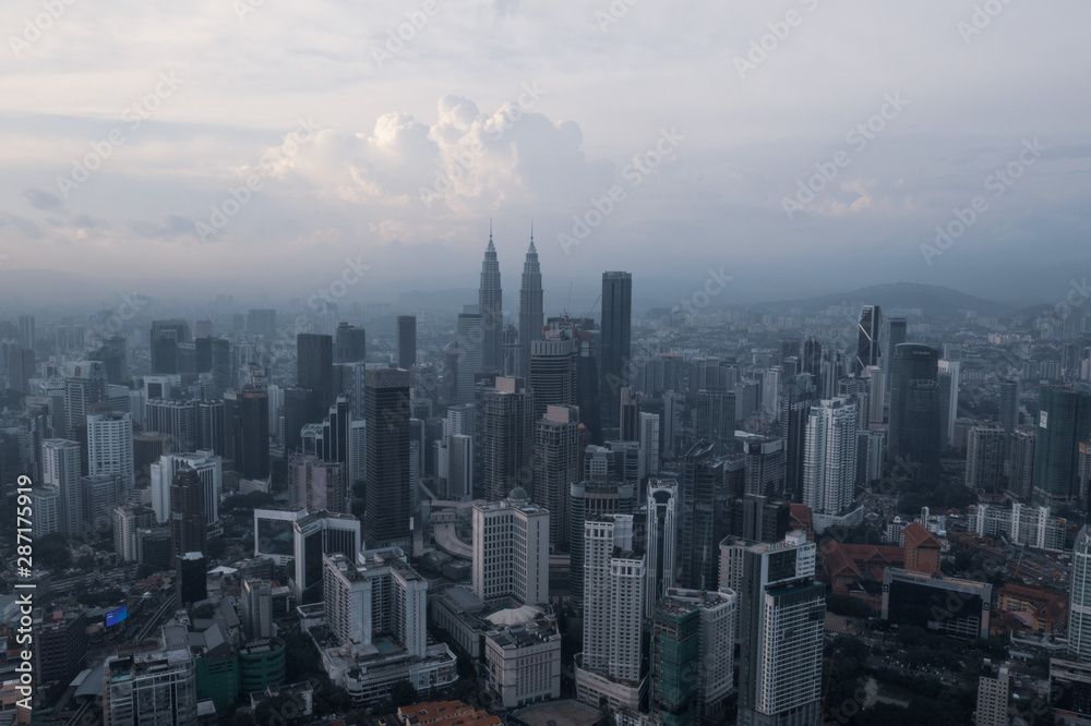 Aerial drone view of Kuala Lumpur city skyline during cloudy day