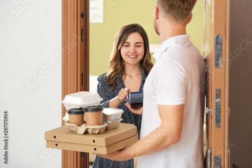 Woman paying courier for fo...