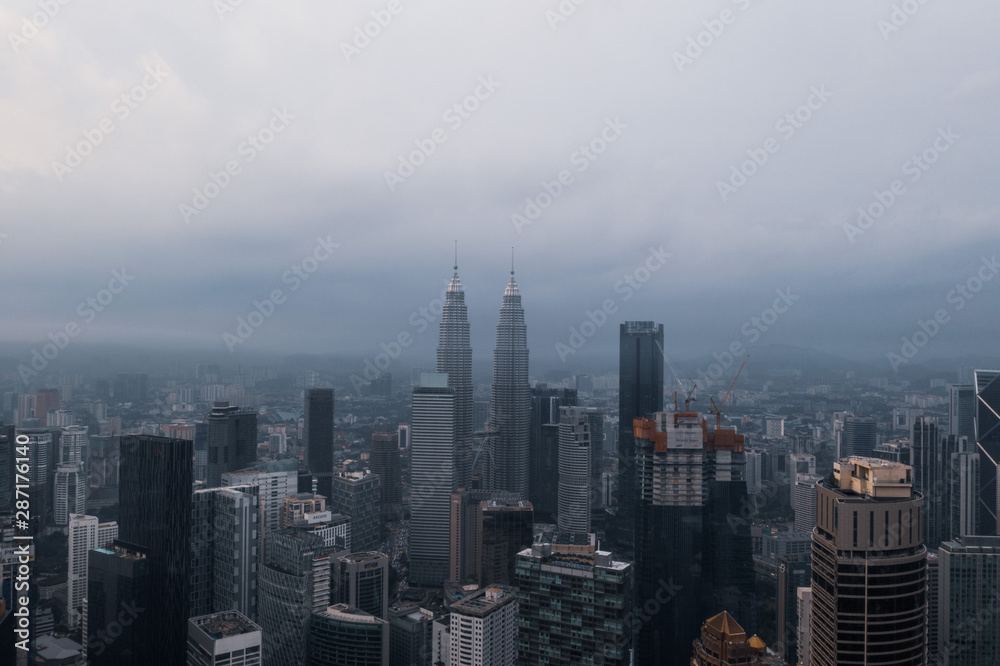 Aerial drone view of Kuala Lumpur city skyline during cloudy day
