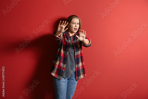 Woman having panic attack on color background