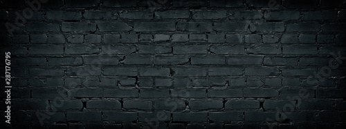 Wide black brick wall texture. Dark old masonry background. Rough brickwork