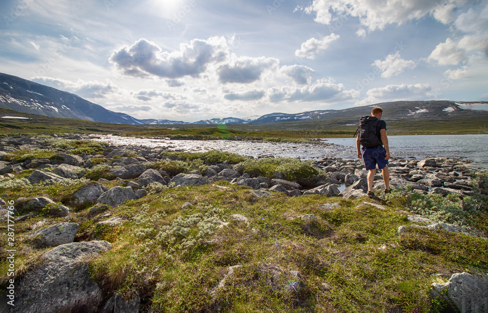 person hiking at the river in the fjell, scenic landscape