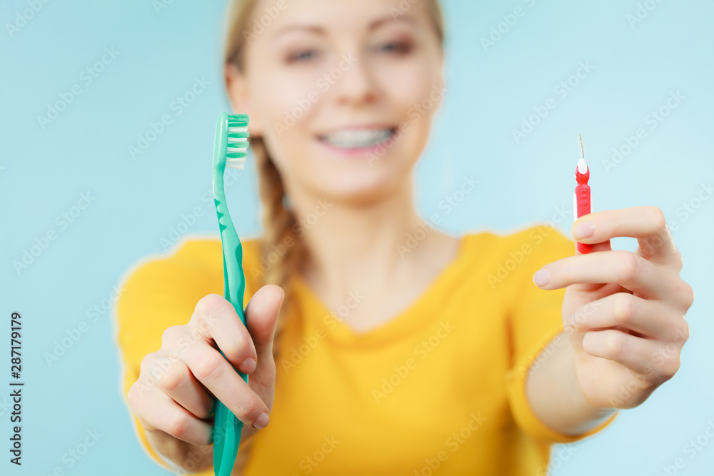 Girl with teeth braces using interdental and traditional brush Girl with teeth braces using interdental and traditional brush