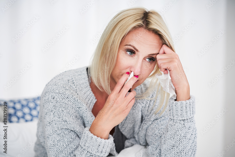 Adult woman feeling unewll with runny nose at home Adult woman feeling unewll with runny nose at home