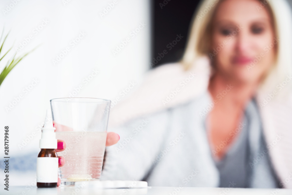 Adult woman feeling unewll and taking tablets at home Adult woman feeling unewll and taking tablets at home