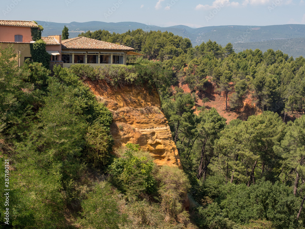 ROUSSILLON, France, august 2019: A view of the red ochre cliffs of Roussillon, ranked as one of the most beautiful villages of France