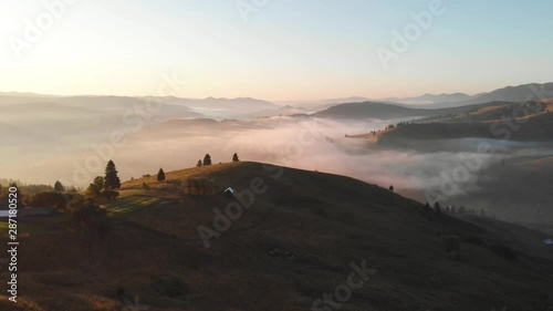 Aerial view of foggy sunrise over hills and the forest in Bucovina - Romania photo