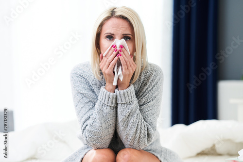 Adult woman feeling unewll with runny nose at home