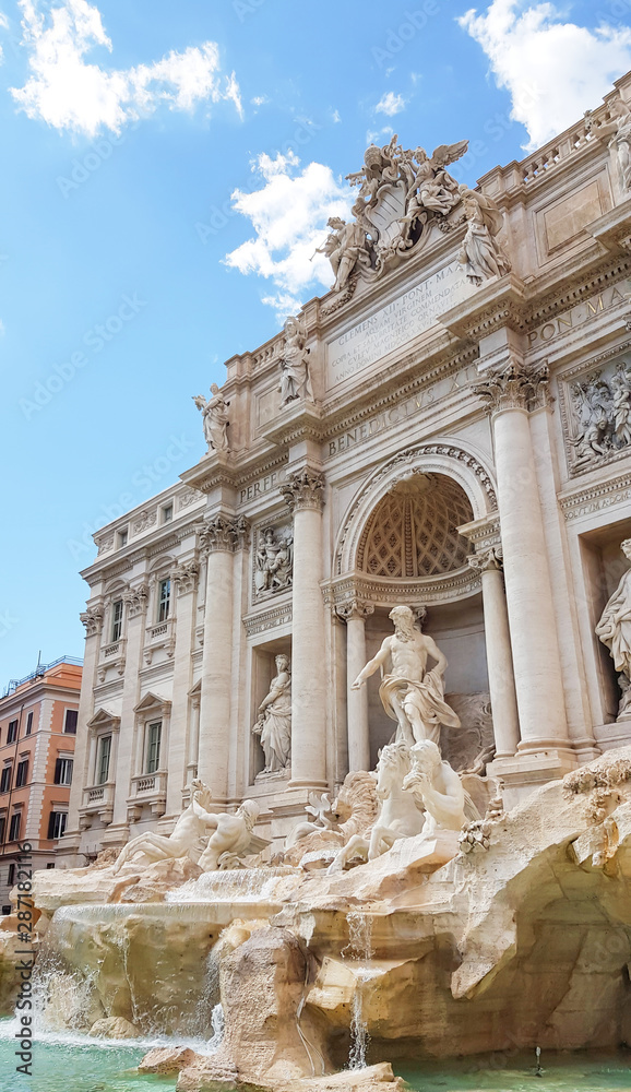 Rome trevi fountain and art statue (Fontana di Trevi) in Rome, Italy with bright day blue sky. Trevi is most famous fountain of Rome. Architecture and landmark of Rome. Postcard of Rome.