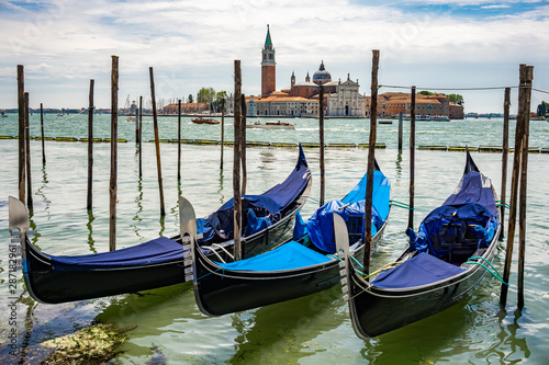 Traditional gondolas floating on the canal in Venice, in front of island San Giorgio Maggiore, Italy © BGStock72