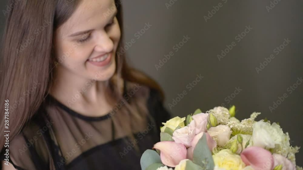 Smiling girl looks at a bouquet in a flower shop Smiling girl looks at a bouquet in a flower shop