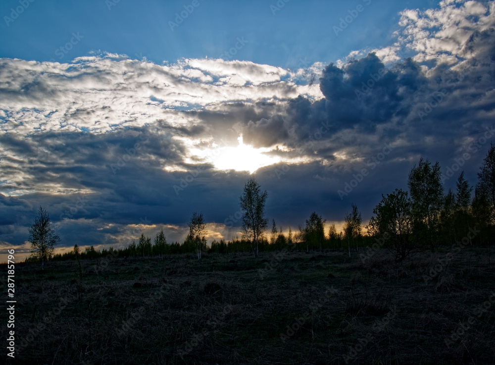 bright sunset in spring through the clouds, Russia.