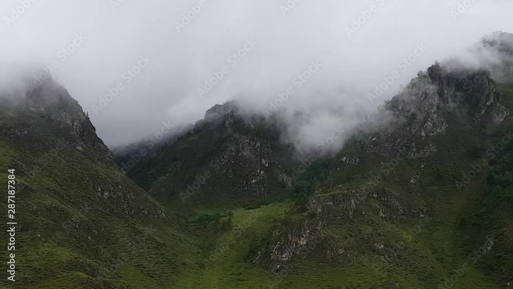 Fluffy clouds on a cloudy day float past the tops of the mountains. A summer trip to Altay. Hiking in the mountains of Russia Fluffy clouds on a cloudy day float past the tops of the mountains. A summer trip to Altay. Hiking in the mountains of Russia