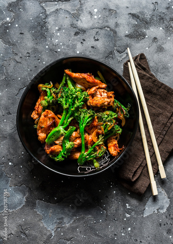 Teriyaki stir fry chicken with broccoli on dark background, top view. Asian style food