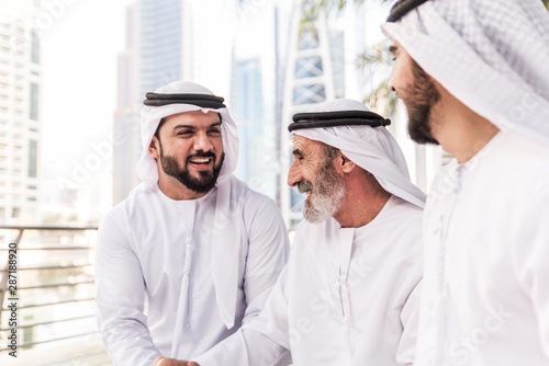 Businessmen in Dubai speaking about business. Local people with traditional clothes