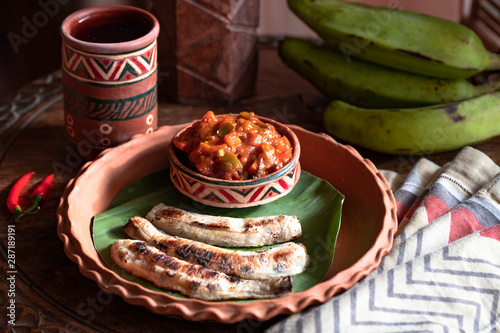 chili plantains with spicy tomato sauce. Healthy food concept. Traditional African and Nigerian cuisine. Selective focus. fried bananas plantains. african food. African cuisine called Boli and sauce.