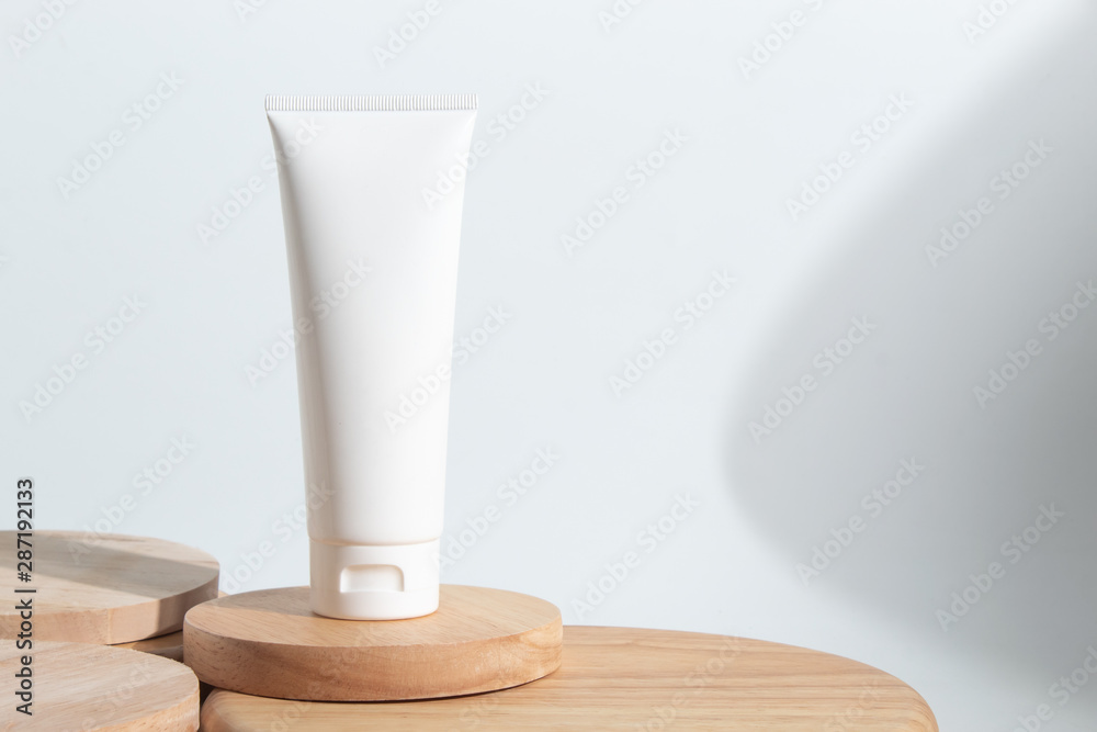 cosmetic bottle tube packaging and long shadow on white background wood plate dish in beauty skincare concept - obrazy, fototapety, plakaty 