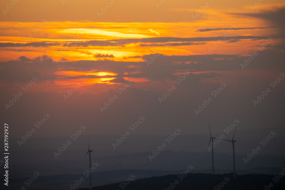 Wind turbines in the front of a red sunset