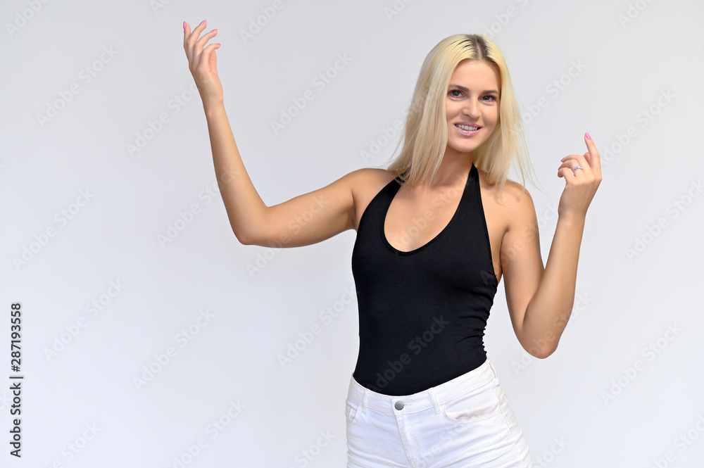 Portrait of a cute girl, a young blonde woman with beautiful curly hair in a black T-shirt and white shorts on a white background. Beauty, brightness, smile, emotions. Portrait of a cute girl, a young blonde woman with beautiful curly hair in a black T-shirt and white shorts on a white background. Beauty, brightness, smile, emotions.