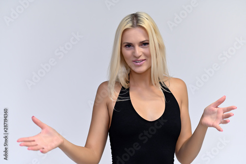 Portrait of a cute girl, a young blonde woman with beautiful curly hair in a black T-shirt on a white background. Beauty, brightness, smile, emotions. © Вячеслав Чичаев