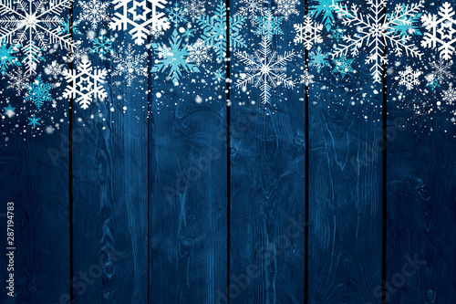 Картината върху платно Blue Christmas winter background with snowflakes on wood