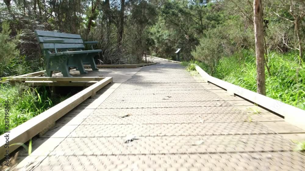 POV fast walk through nature reserve vegetation with camera low over the wooden boardwalk in Australia POV fast walk through nature reserve vegetation with camera low over the wooden boardwalk in Australia