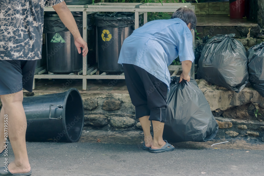 Female worker sort the garbage and packed in black bags for transportation convenience. Female worker sort the garbage and packed in black bags for transportation convenience.