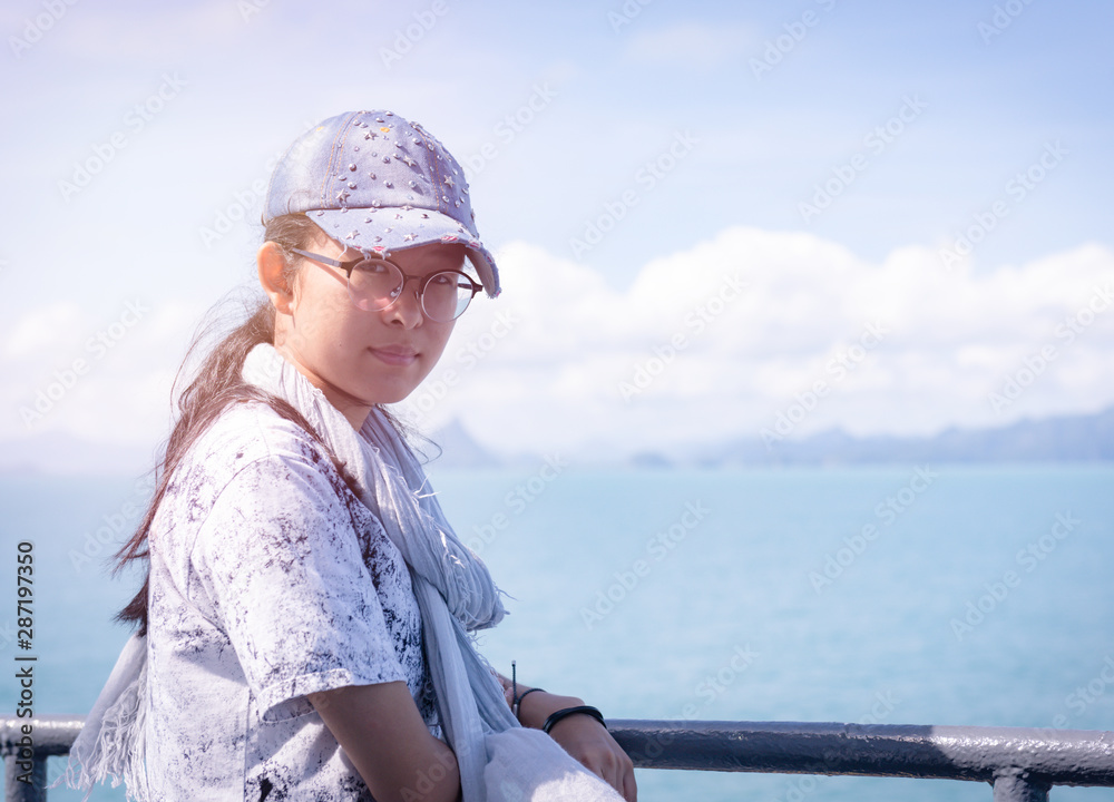Happy asian teenage girl smiling face on ship in blue ocean