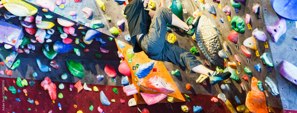 Fototapeta premium [ライフスタイル] 美容とダイエットを兼ねてボルダリングスタジオで上級課題に果敢に挑む主婦クライマー