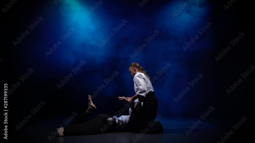 Two fighters participants of the training in special clothes of aikido hakama work out the methods of single combat Two fighters participants of the training in special clothes of aikido hakama work out the methods of single combat