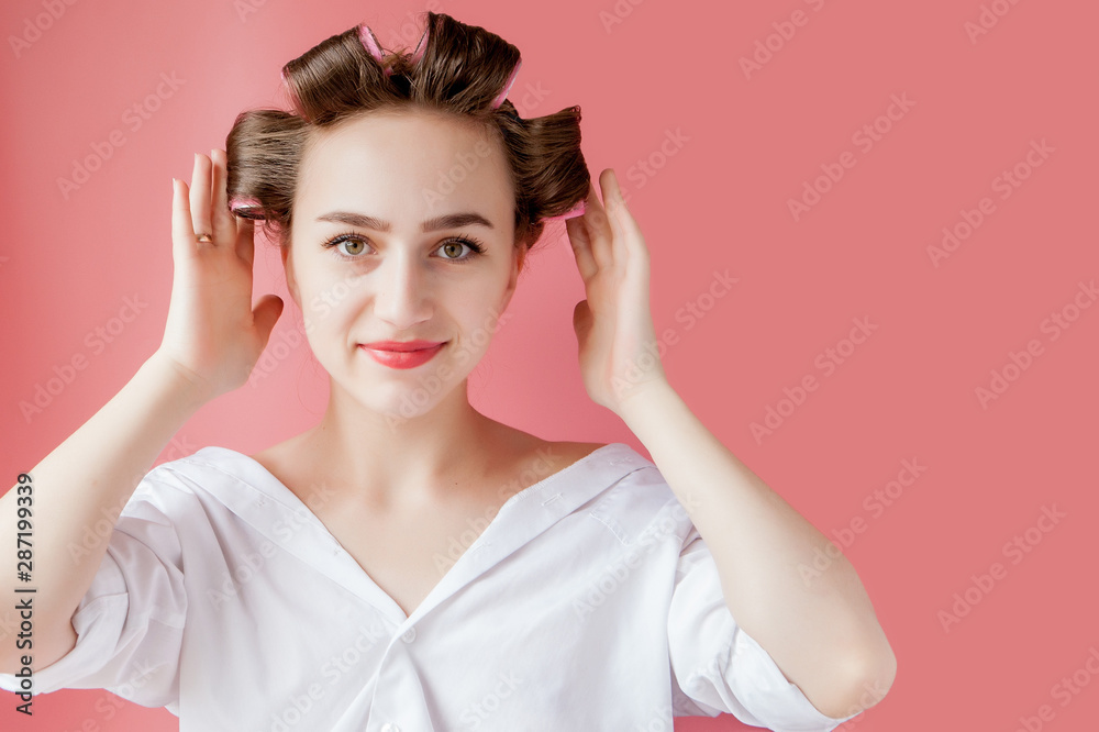 Beautiful girl in hair curlers on pink background Beautiful girl in hair curlers on pink background