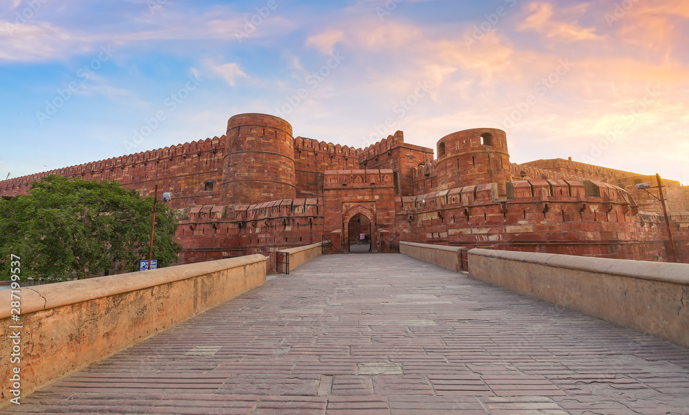Agra Fort red sandstone medieval fort in panoramic view at sunrise. Agra Fort is a UNESCO World Heritage site in the city of Agra India.
