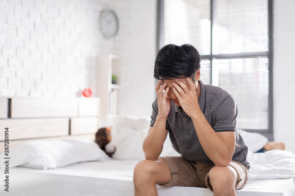 couple,they have problems with quarrel. man sitting in bed he is having a headache couple,they have problems with quarrel. man sitting in bed he is having a headache