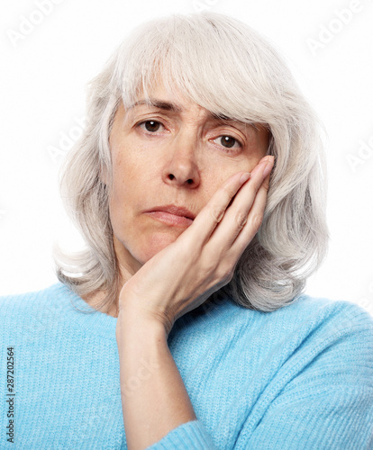 Lifestyle, health and people concept: Elderly woman suffering from toothache on white background